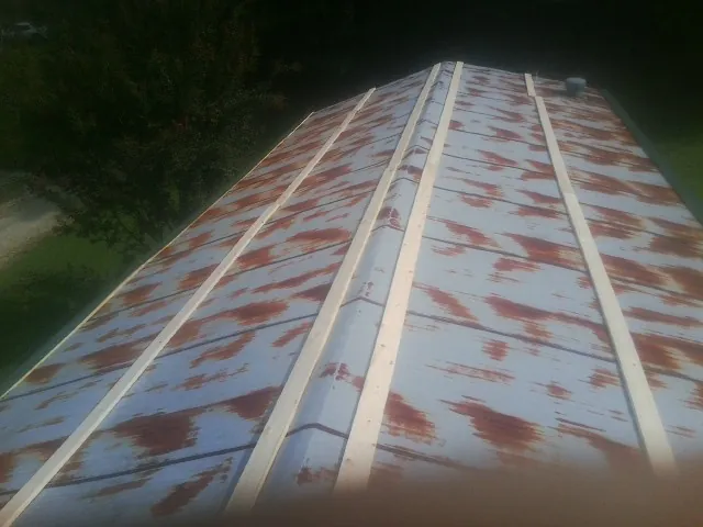 Rusted metal roof panels with new wood purlins before replacement — Storm Damage Roof Repair in Miller Place by Roofing Brothers