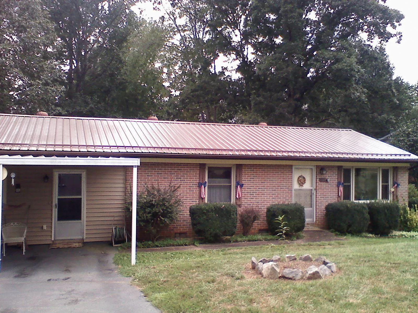 Bronze metal roof and carport on a brick ranch home — Roof Repair work by our crew in Miller Place